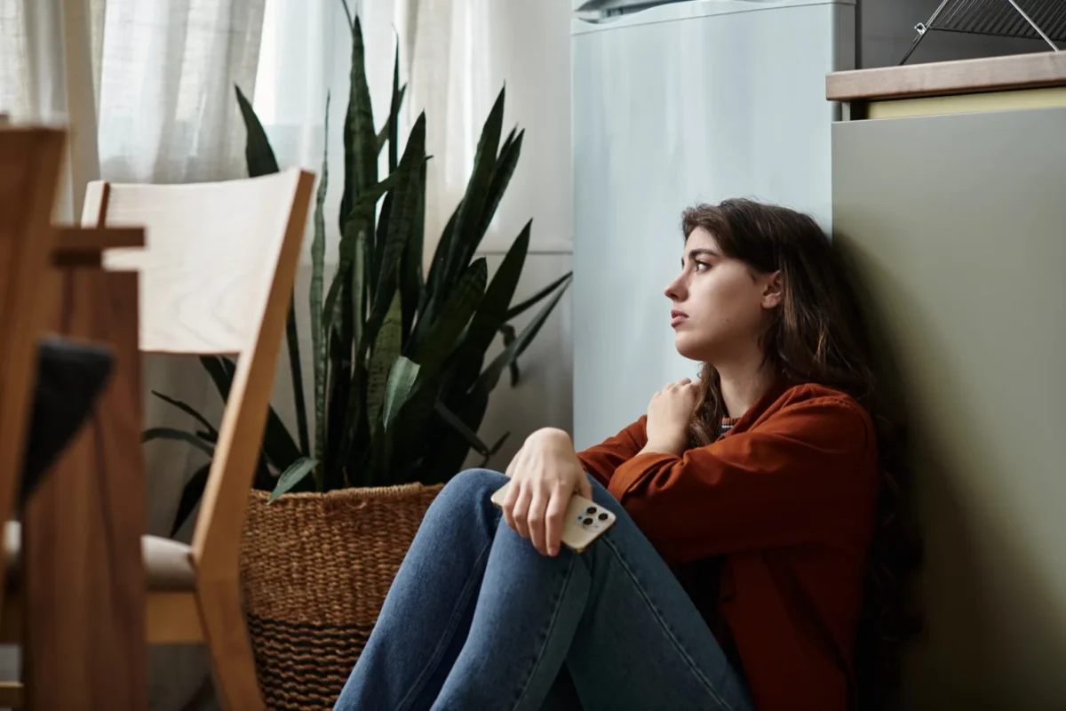 How To Get A Man To Chase You (No Games Required) sad woman holding phone