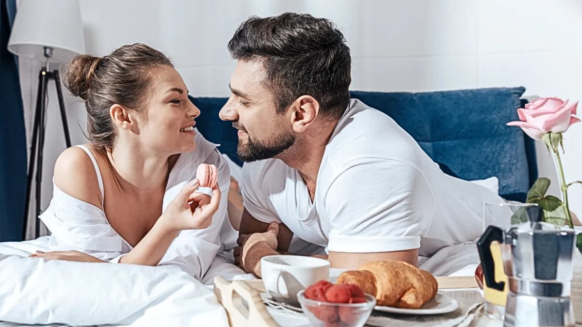 happy couple having breakfast in bed