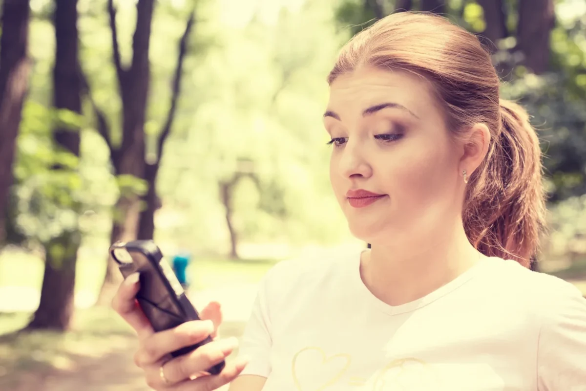 How To Get Back Together With An Introvert skeptical woman looking at phone