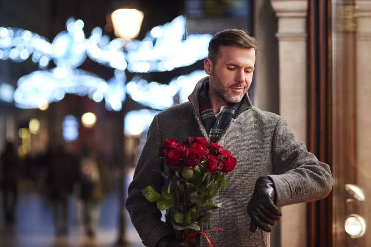 attractively dressed man holding roses