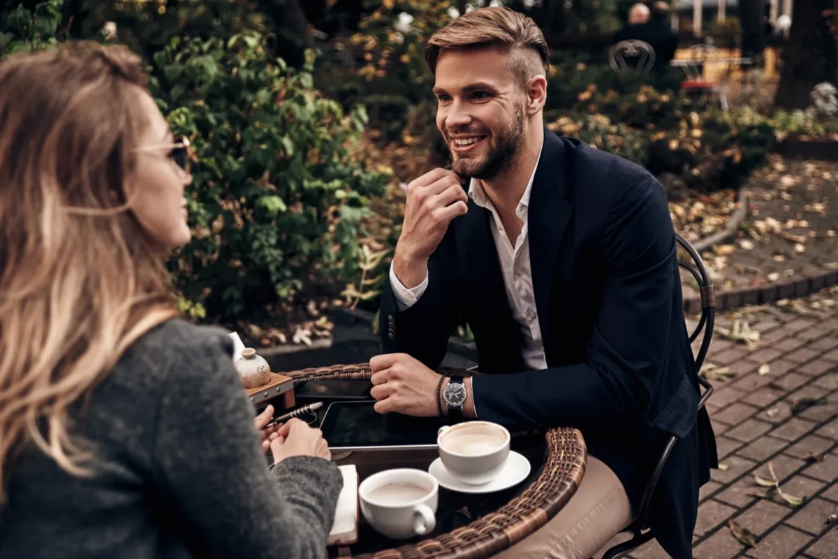 man smiling at woman during coffee date