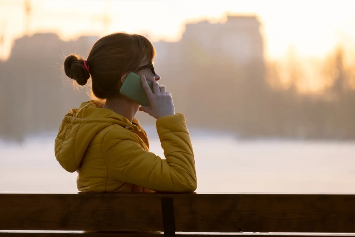 “Will He Come Back?” 4 Hopeful Signs Your Ex Boyfriend Will Get In Touch woman on phone sitting outside