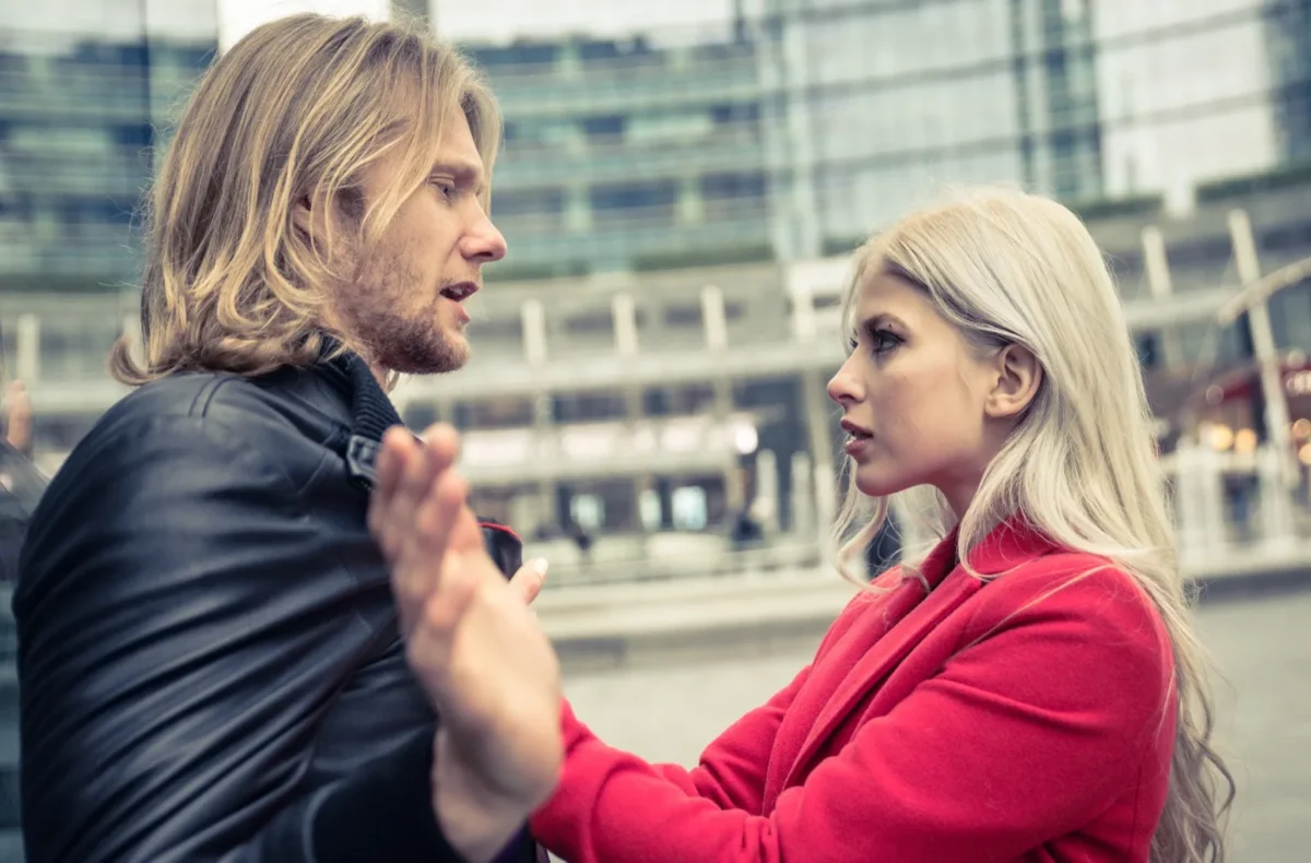 woman aggressively grabbing man's collar