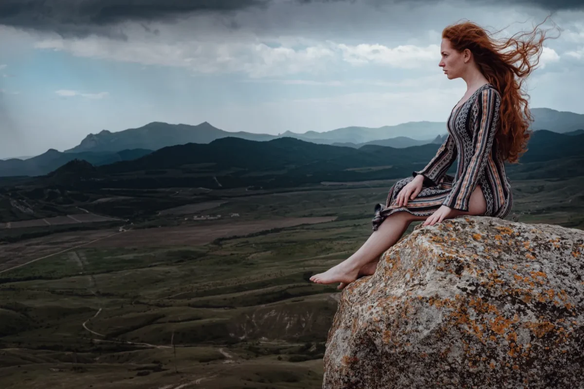 woman sitting on cliff