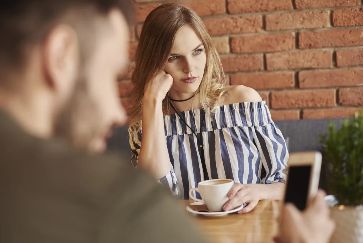 passive aggressive woman looking away man on phone