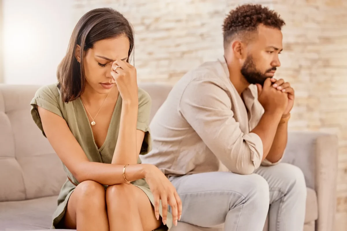 couple sitting on couch apologizing