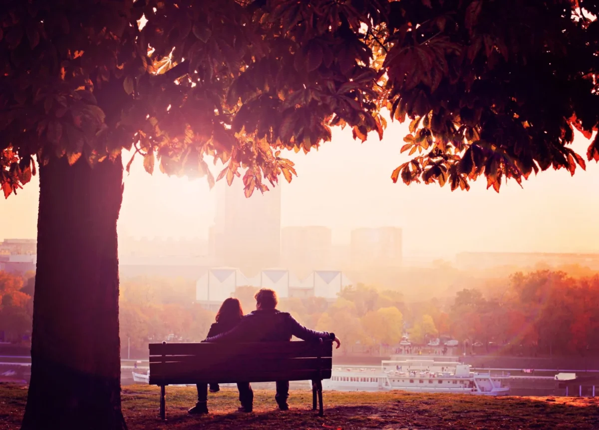 romantic couple sitting on park bench