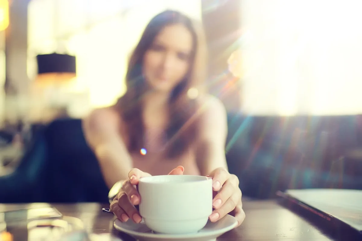 woman pushing coffee forward on table