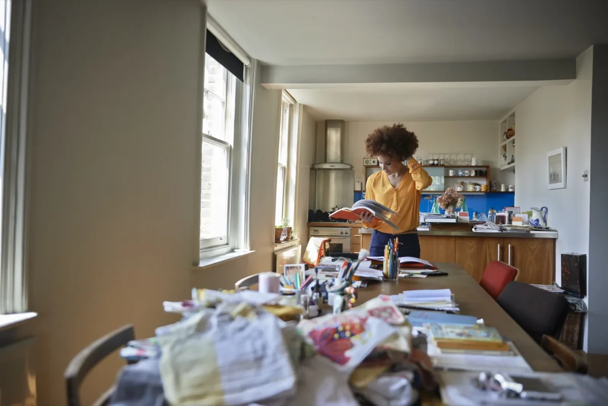 woman standing in front of messy dining room table