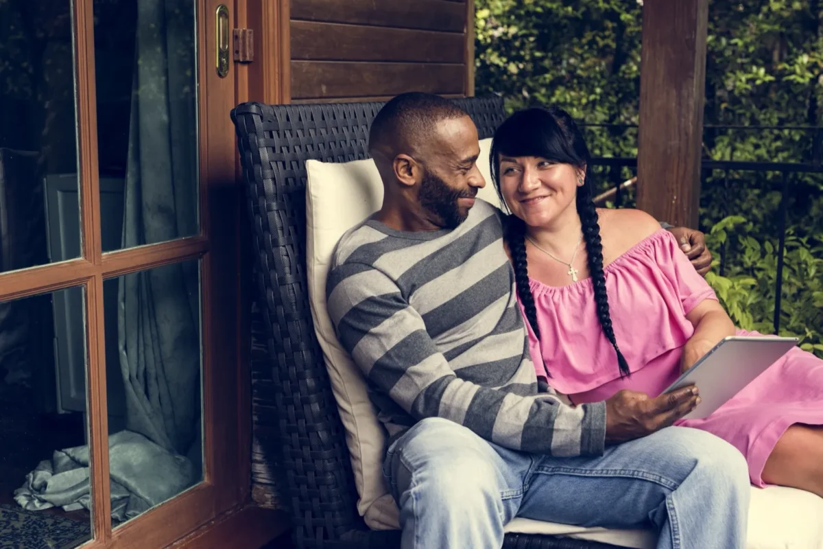 7 Cute Signs Your Relationship Is Actually Pretty Great cheerful couple holding tablet on couch
