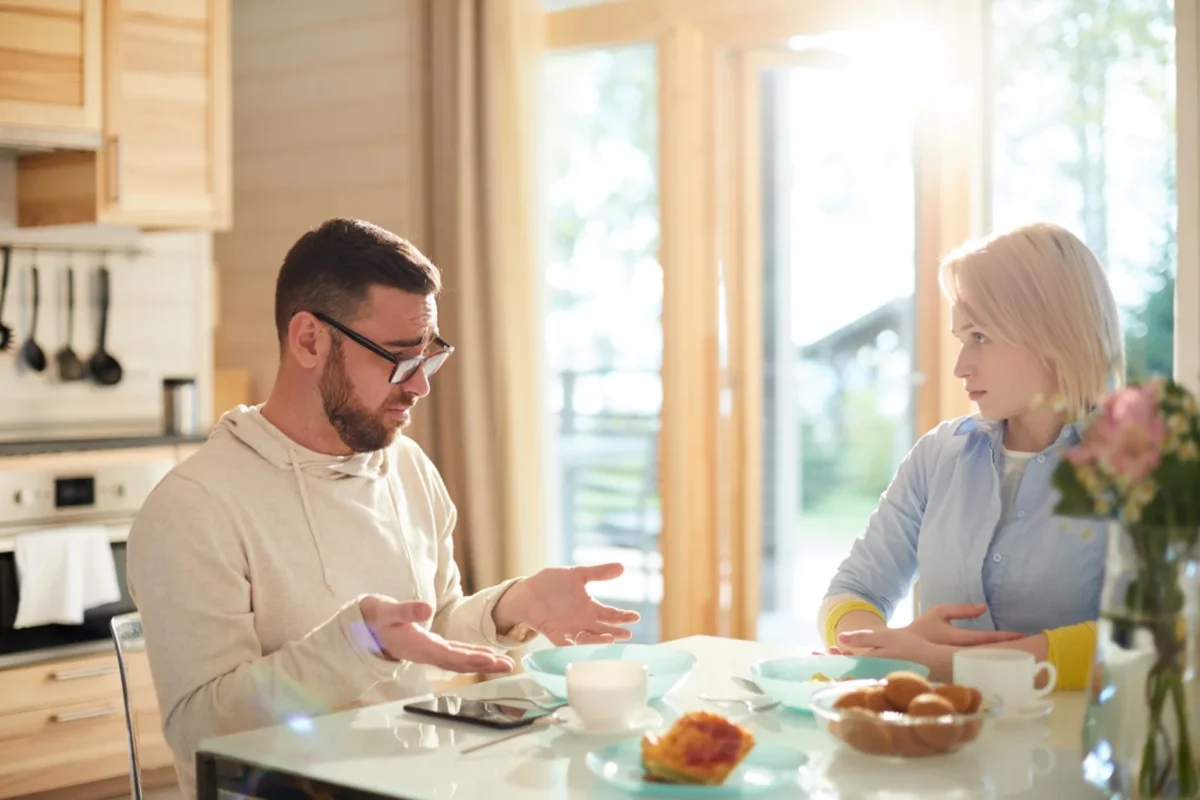 man arguing with woman at table