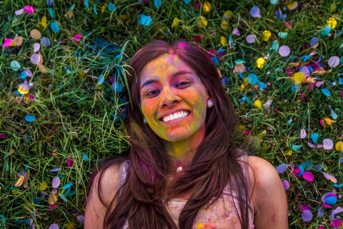 happy woman lying in grass with confetti