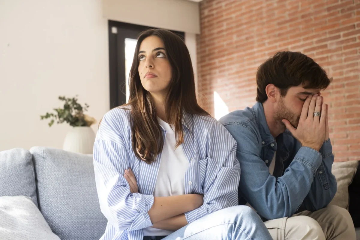 woman with arms crossed and upset man