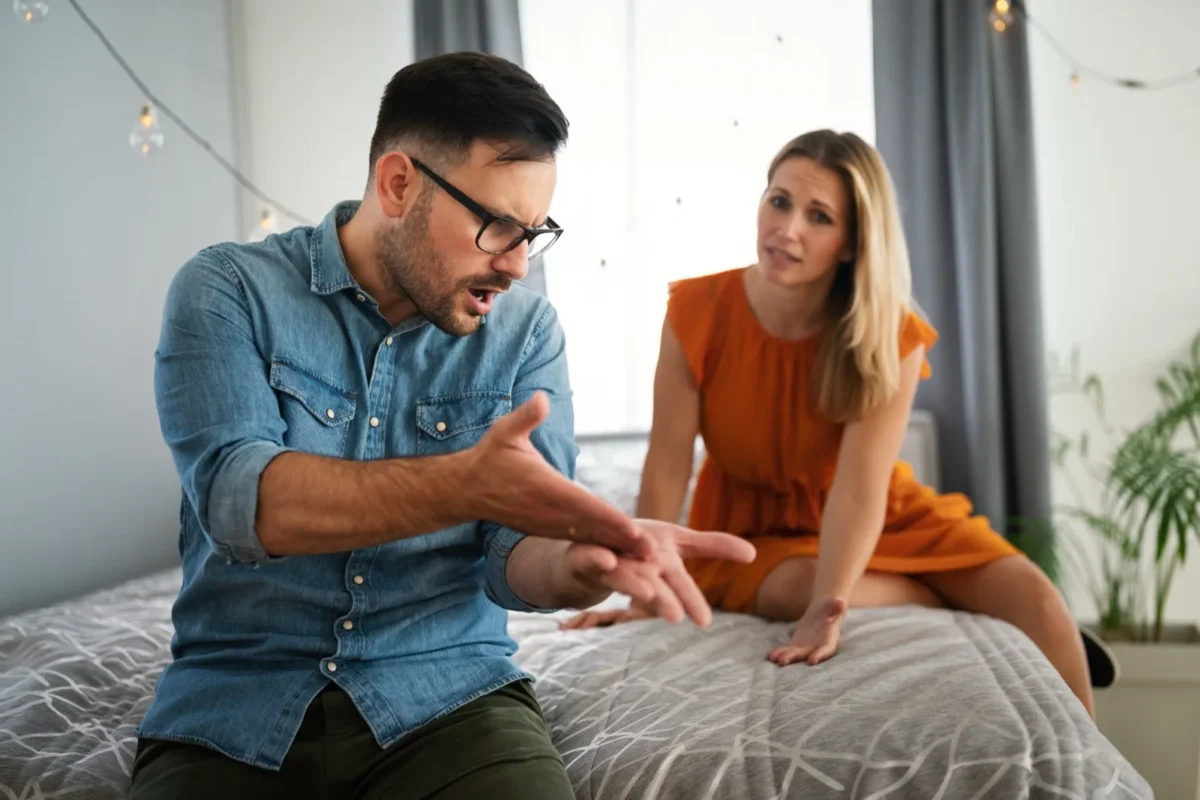 couple resolving argument while sitting on bed