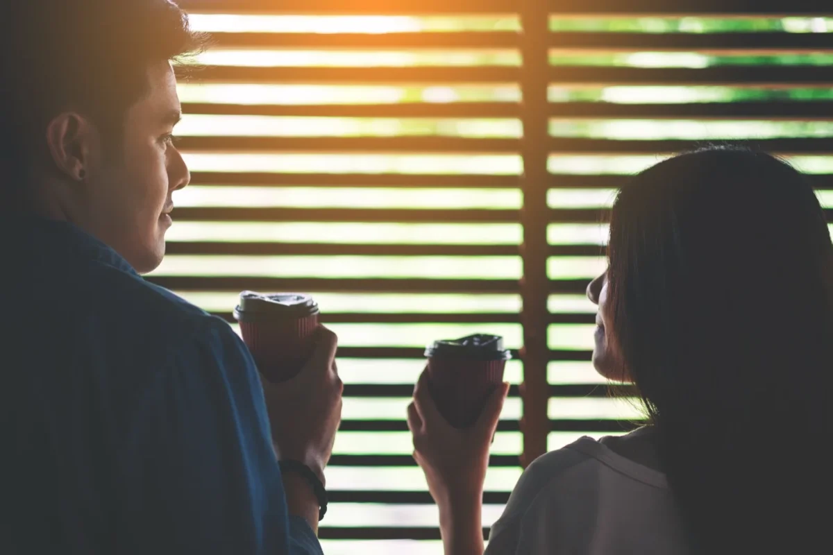 couple drinking coffee by window