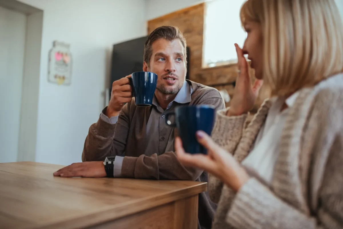 couple talking through disagreement while drinking coffee