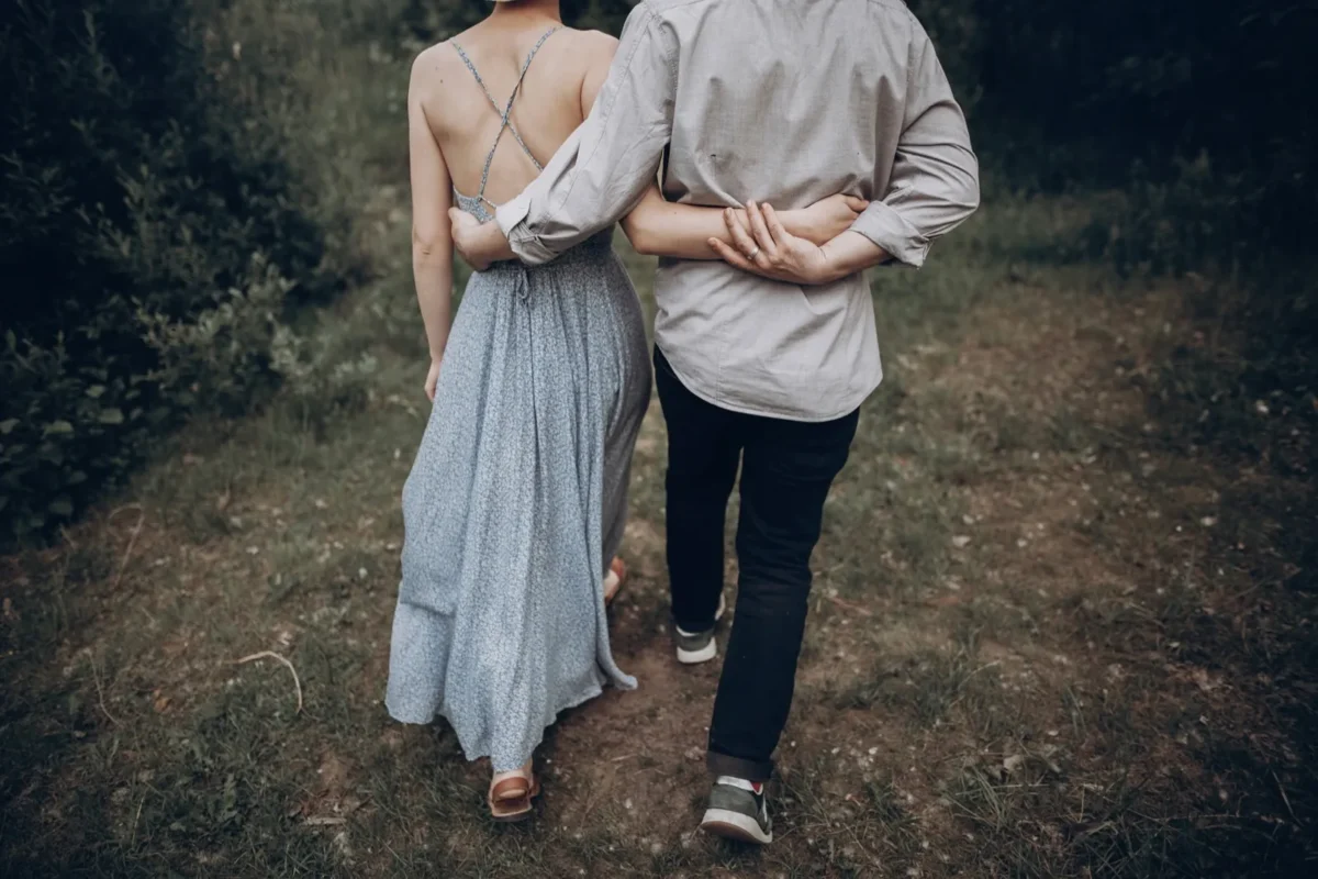 couple from behind embracing walking away