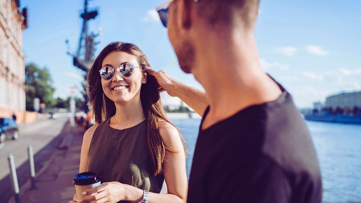 man fixing smiling woman's hair