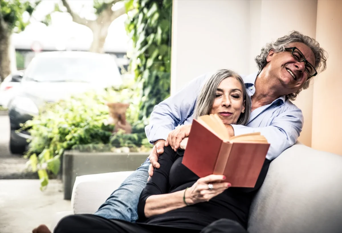 affectionate couple reading book together