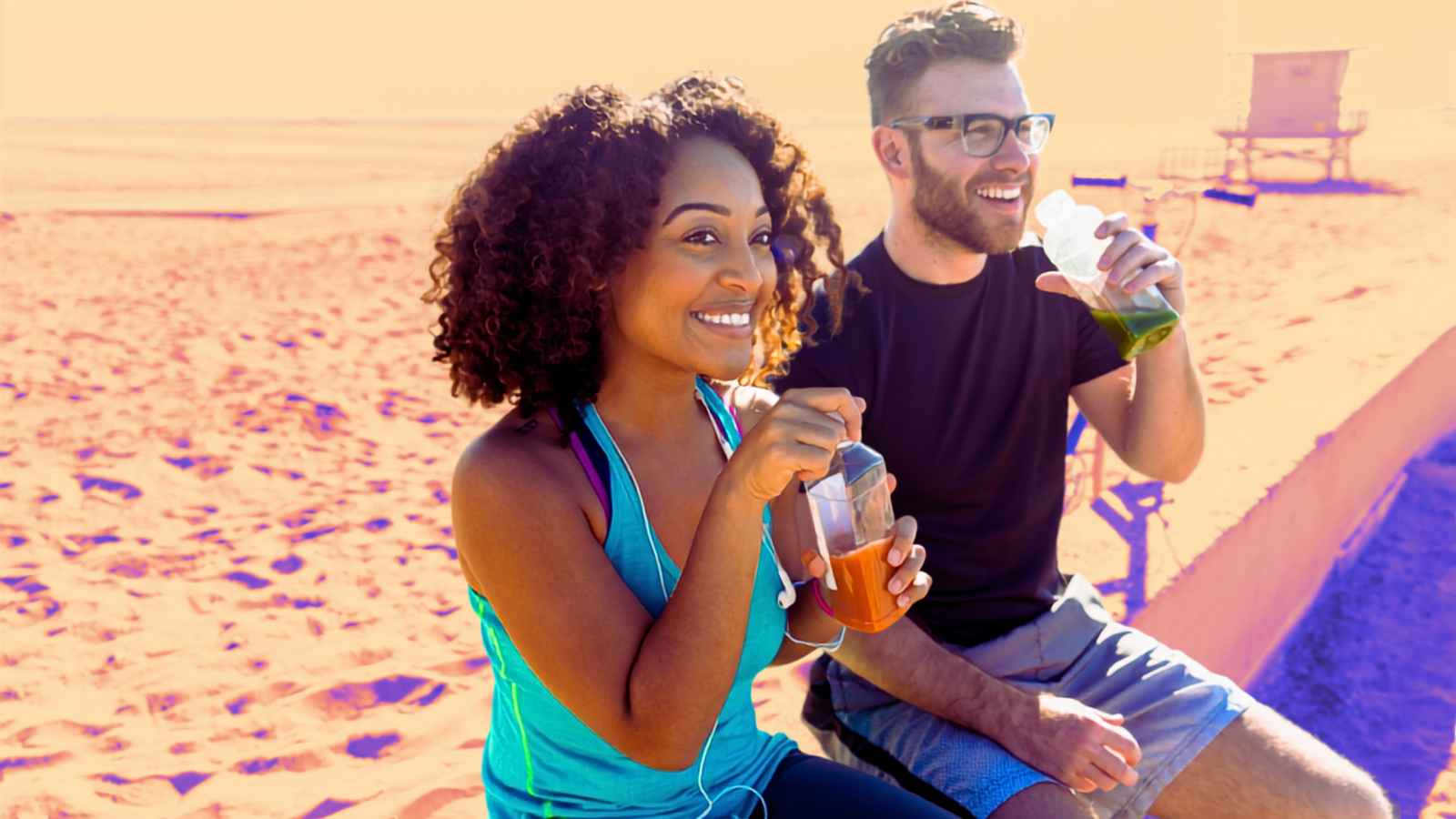 couple having smoothies on beach