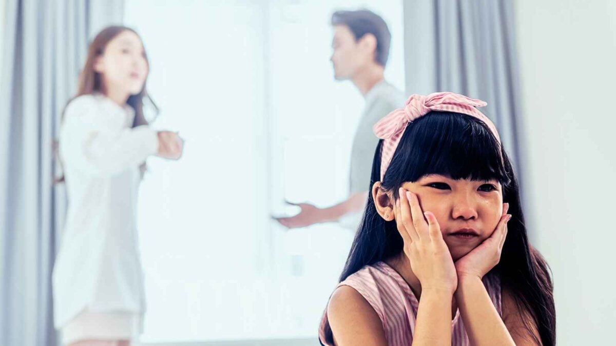 child with parents fighting in background