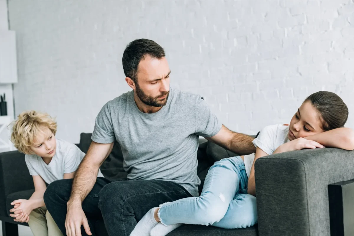 dad with sad kids on couch