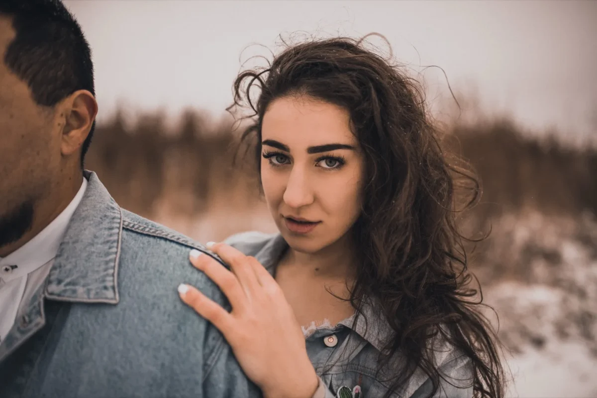 woman holding man's shoulder possessively