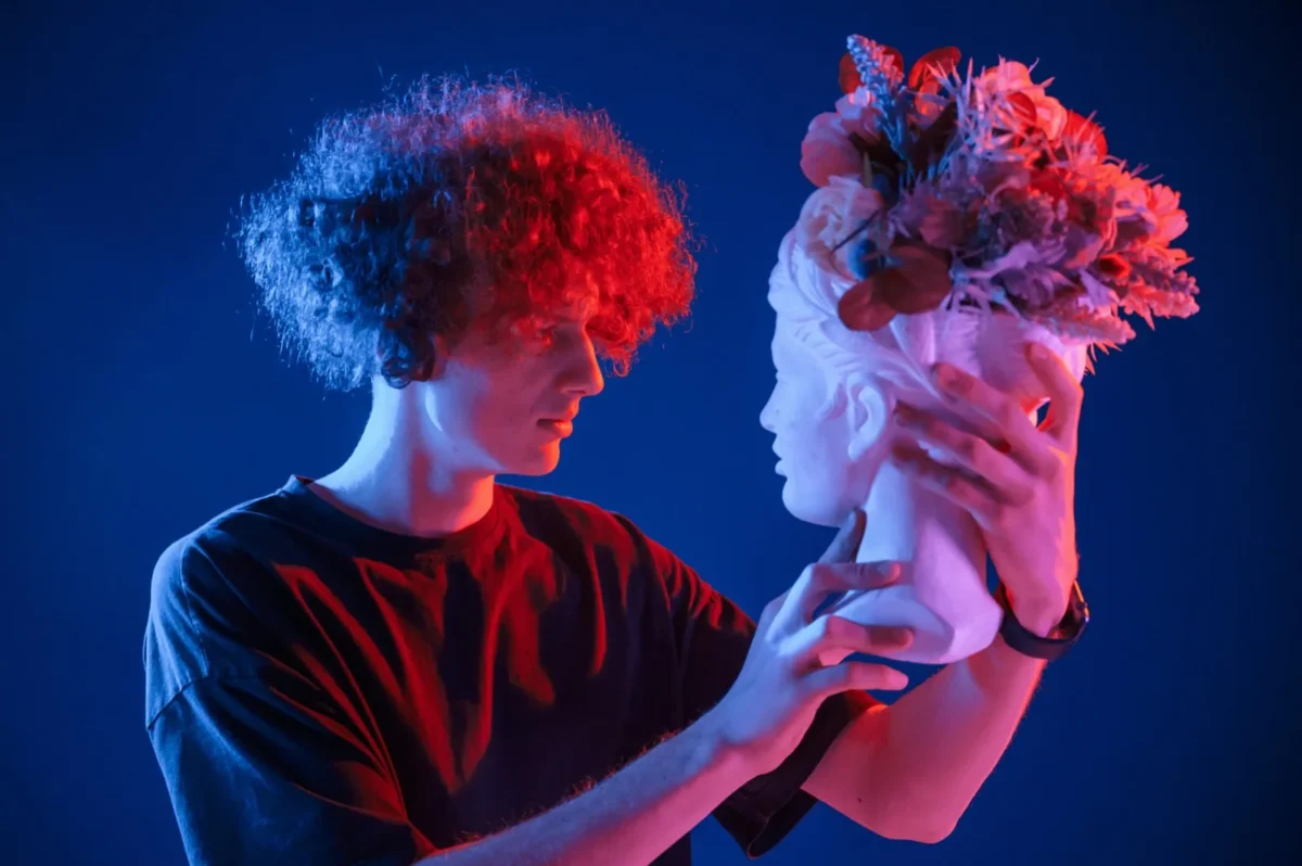 young man holding futuristic female bust