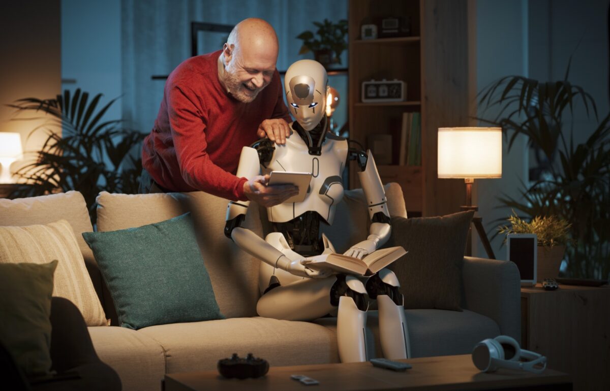 man showing humanoid robot a book and smiling