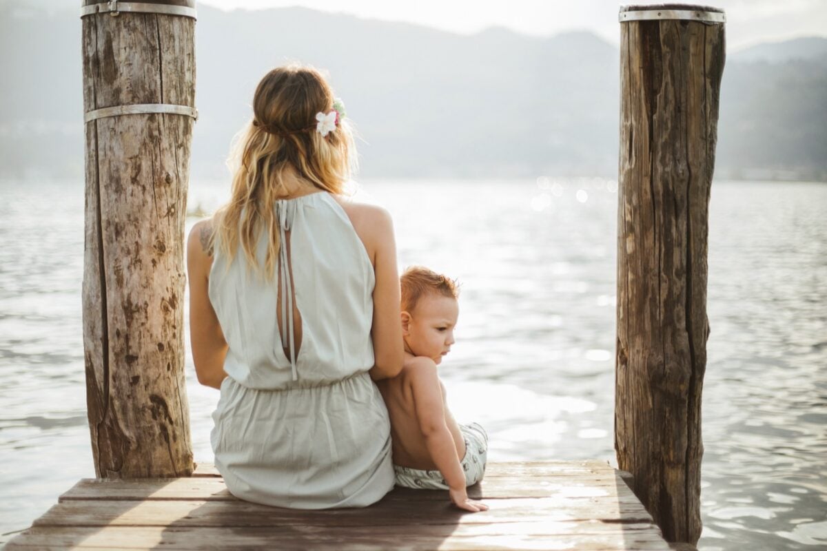 woman and toddler sitting on dock