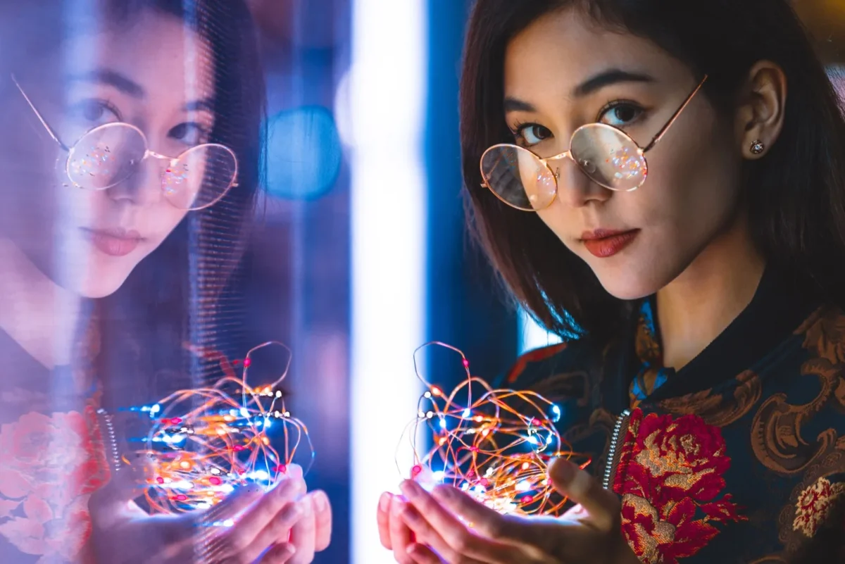 woman holding string lights