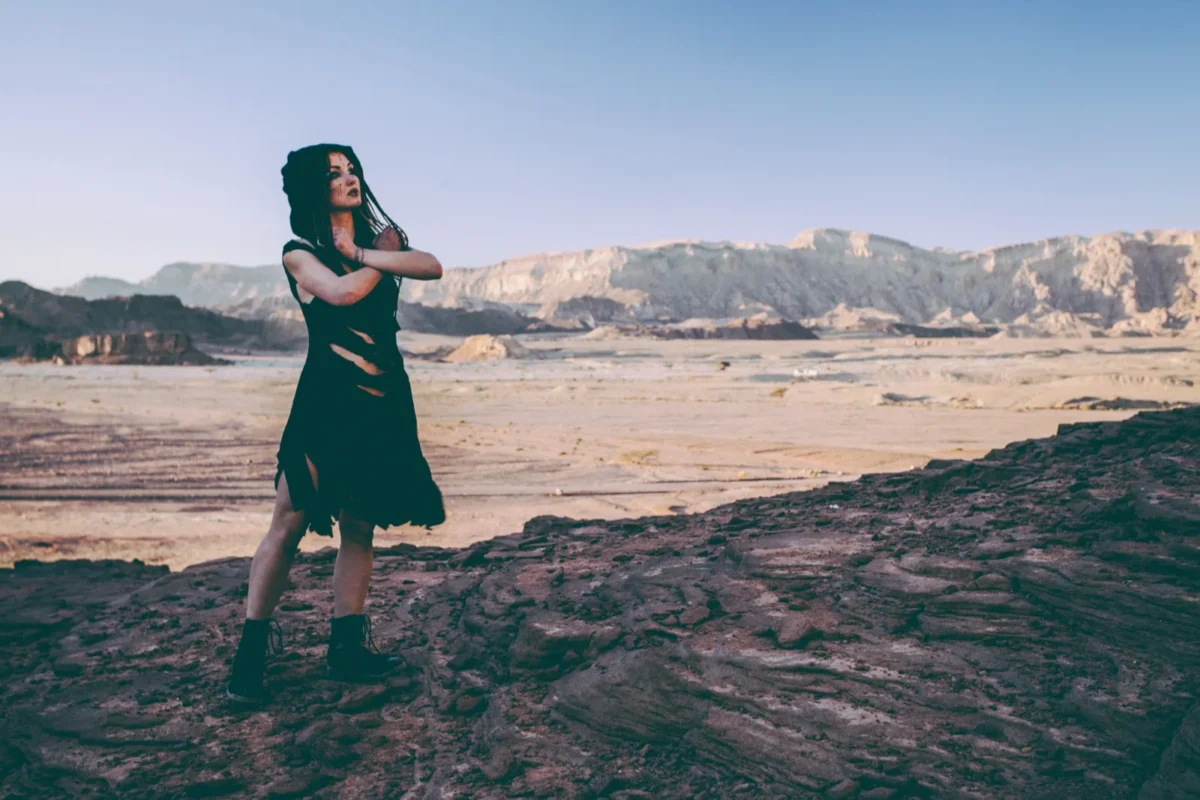 woman standing alone in desert with arms crossed