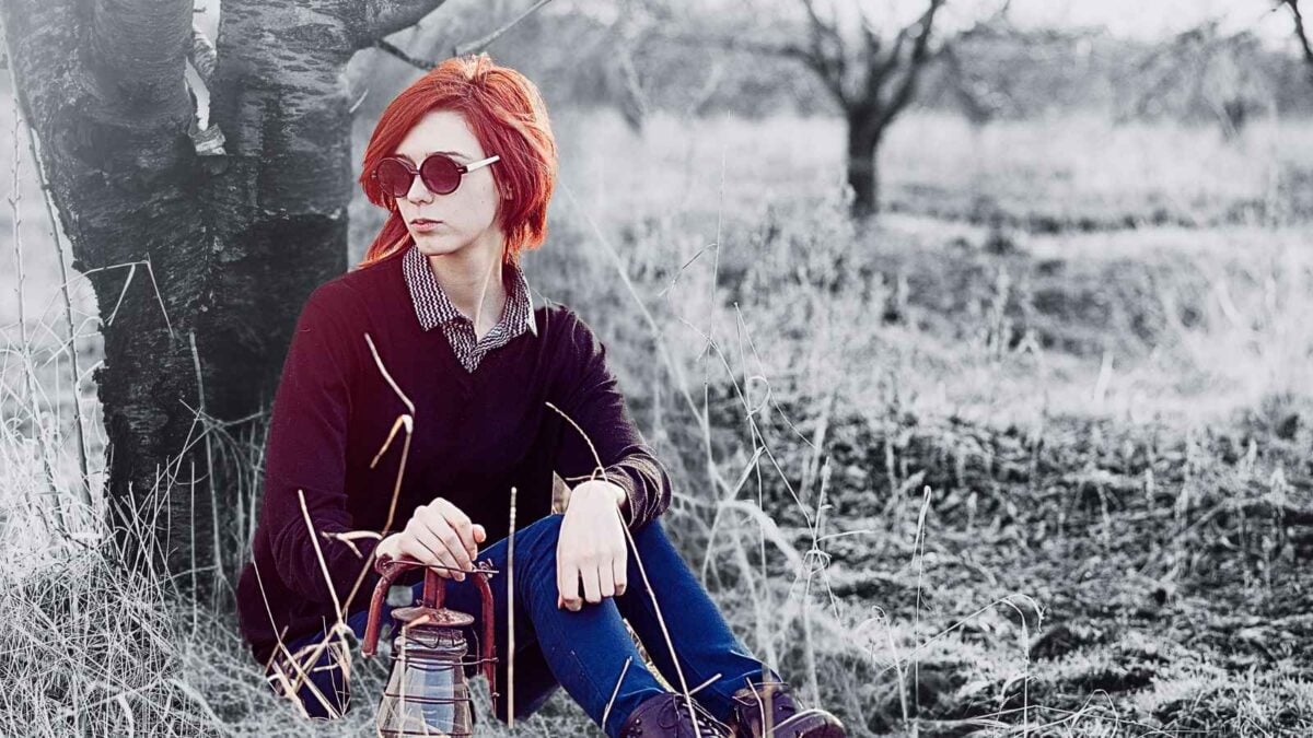 woman sitting against tree