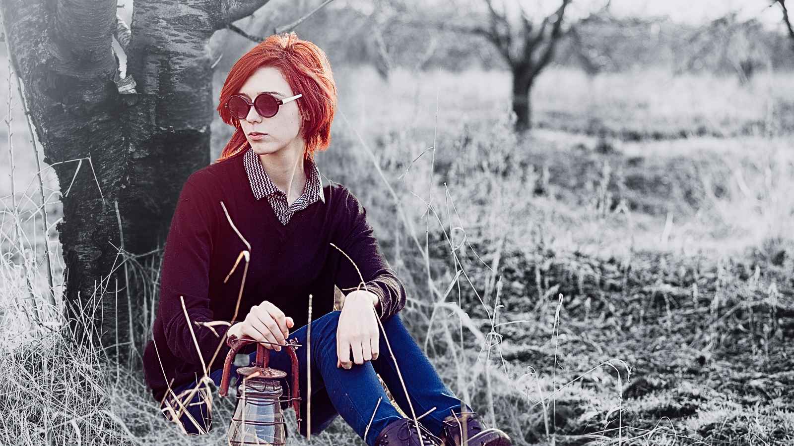 woman sitting against tree