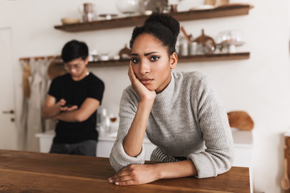 unhappy woman with man in background
