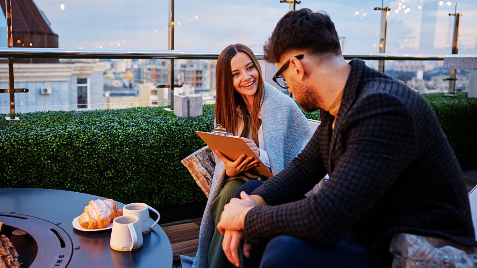 woman talking to man while holding clipboard