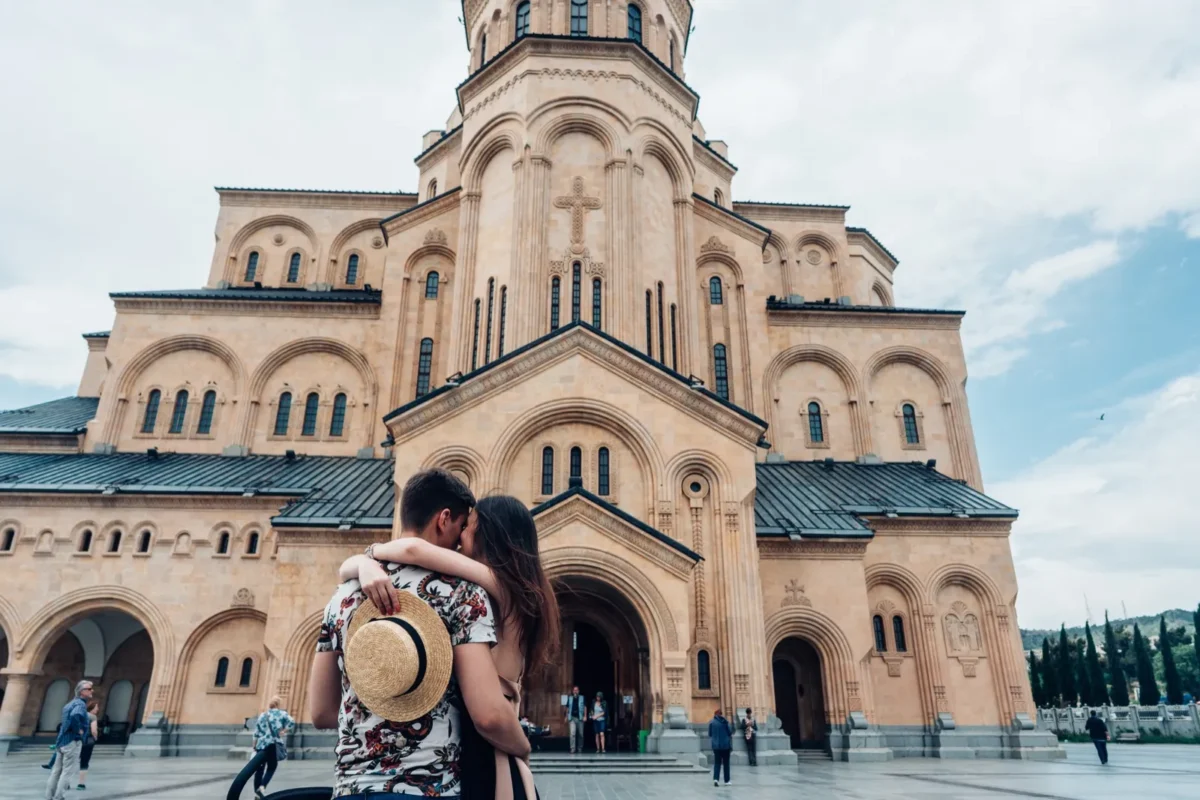 The Real Reason People Refuse to Give Up on the Soulmate Myth couple embracing in front of cathedral