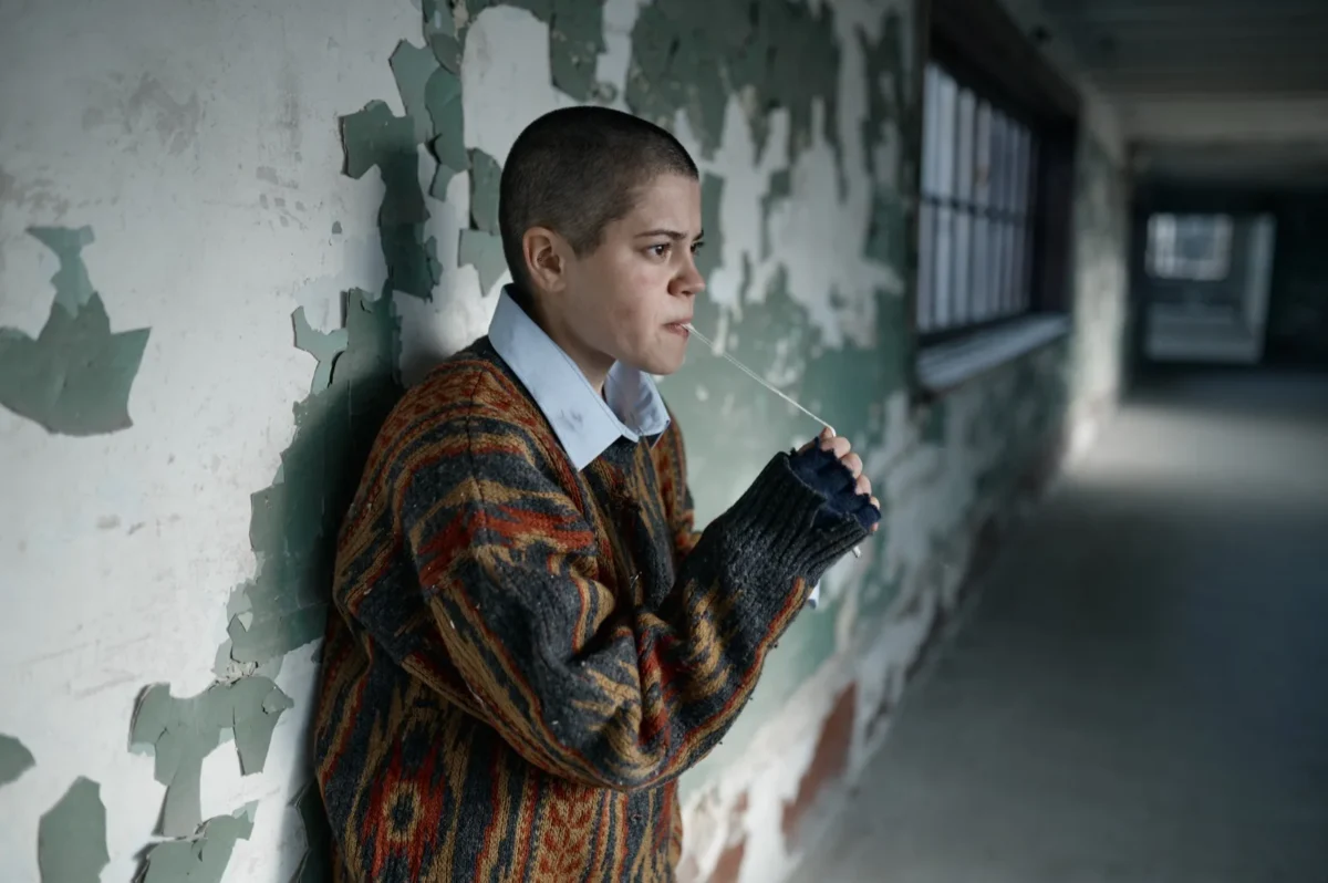 young person leaning against wall