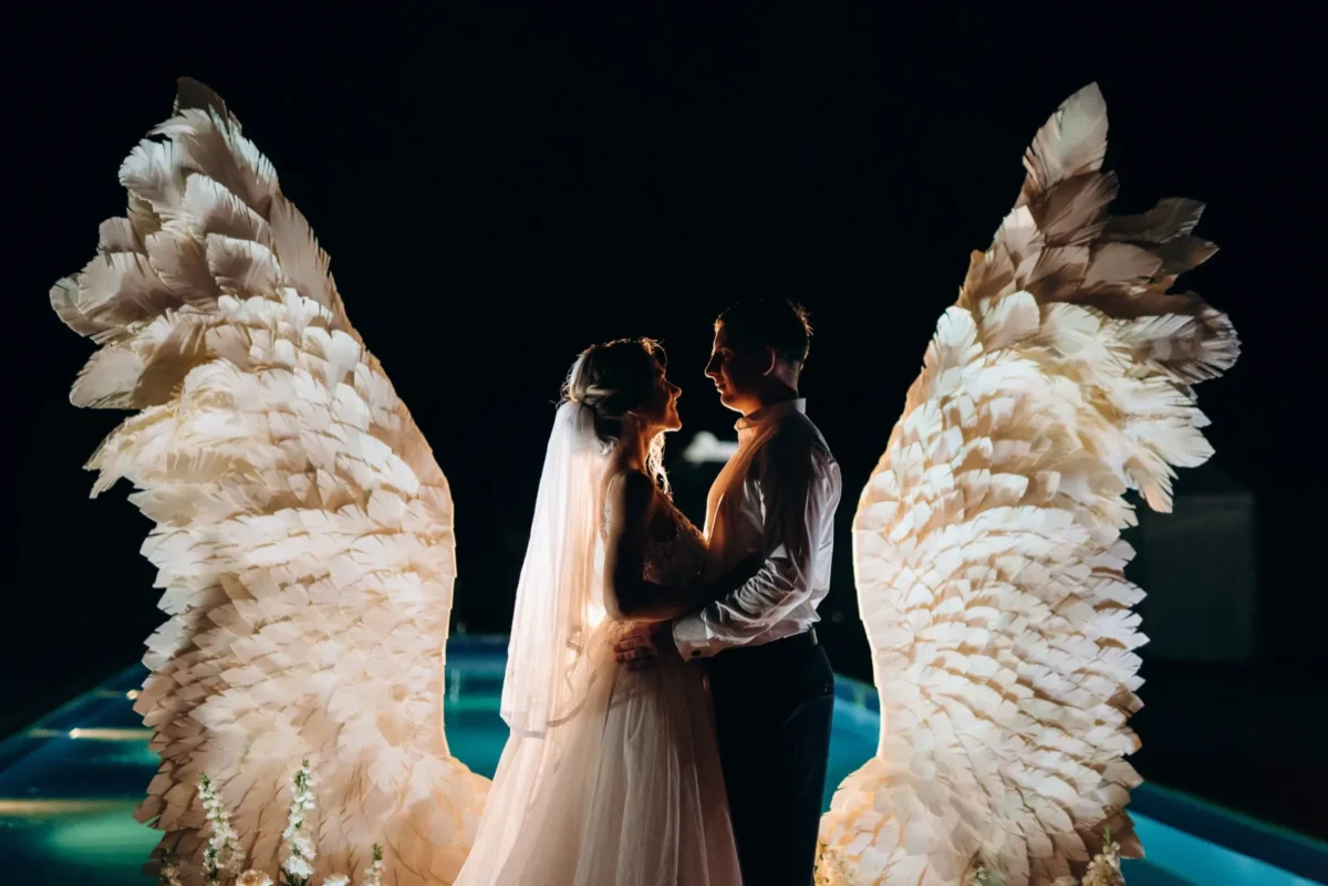 The Real Reason People Refuse to Give Up on the Soulmate Myth romantic couple wedding embrace in front of wings